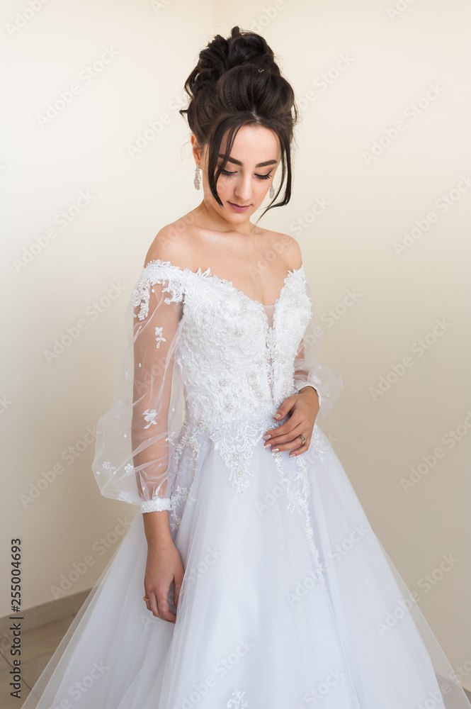 Beautiful bride wearing fashion wedding dress with feathers with luxury delight make-up and hairstyle studio indoor photo shoot Beautiful bride wearing fashion wedding dress with feathers with luxury delight make-up and hairstyle studio indoor photo shoot