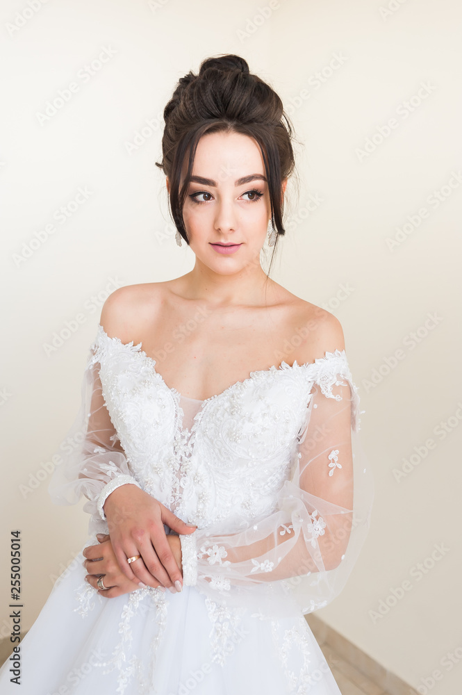 Beautiful bride wearing fashion wedding dress with feathers with luxury delight make-up and hairstyle studio indoor photo shoot Beautiful bride wearing fashion wedding dress with feathers with luxury delight make-up and hairstyle studio indoor photo shoot