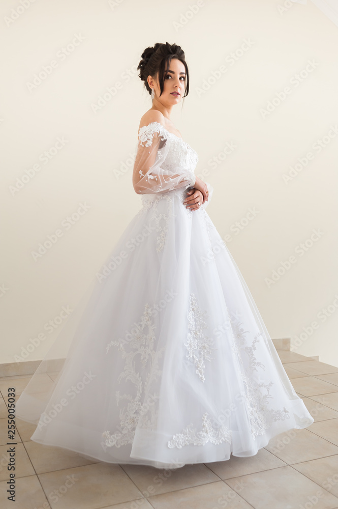 Beautiful bride wearing fashion wedding dress with feathers with luxury delight make-up and hairstyle studio indoor photo shoot Beautiful bride wearing fashion wedding dress with feathers with luxury delight make-up and hairstyle studio indoor photo shoot