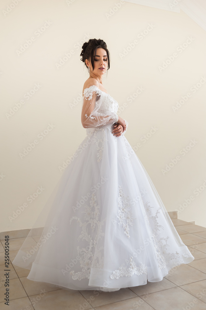 Beautiful bride wearing fashion wedding dress with feathers with luxury delight make-up and hairstyle studio indoor photo shoot Beautiful bride wearing fashion wedding dress with feathers with luxury delight make-up and hairstyle studio indoor photo shoot