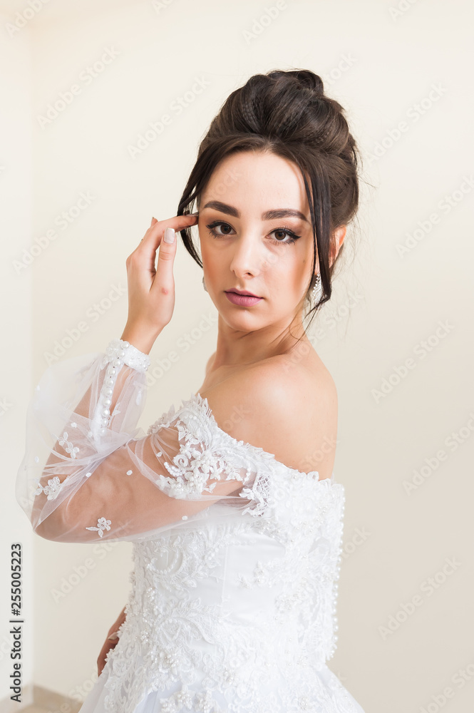 Beautiful bride wearing fashion wedding dress with feathers with luxury delight make-up and hairstyle studio indoor photo shoot Beautiful bride wearing fashion wedding dress with feathers with luxury delight make-up and hairstyle studio indoor photo shoot
