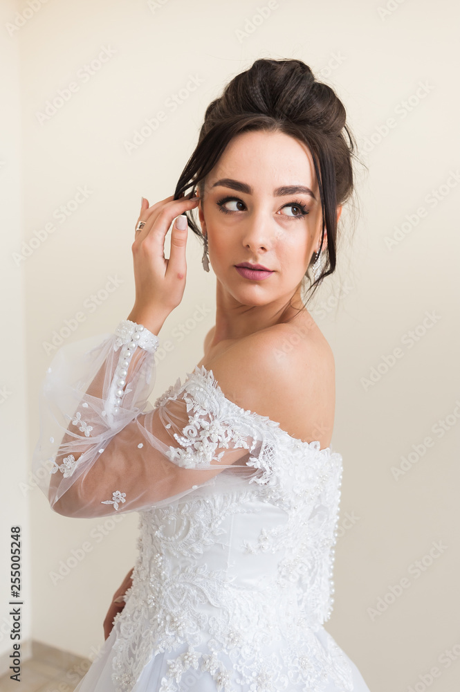 Beautiful bride wearing fashion wedding dress with feathers with luxury delight make-up and hairstyle studio indoor photo shoot Beautiful bride wearing fashion wedding dress with feathers with luxury delight make-up and hairstyle studio indoor photo shoot