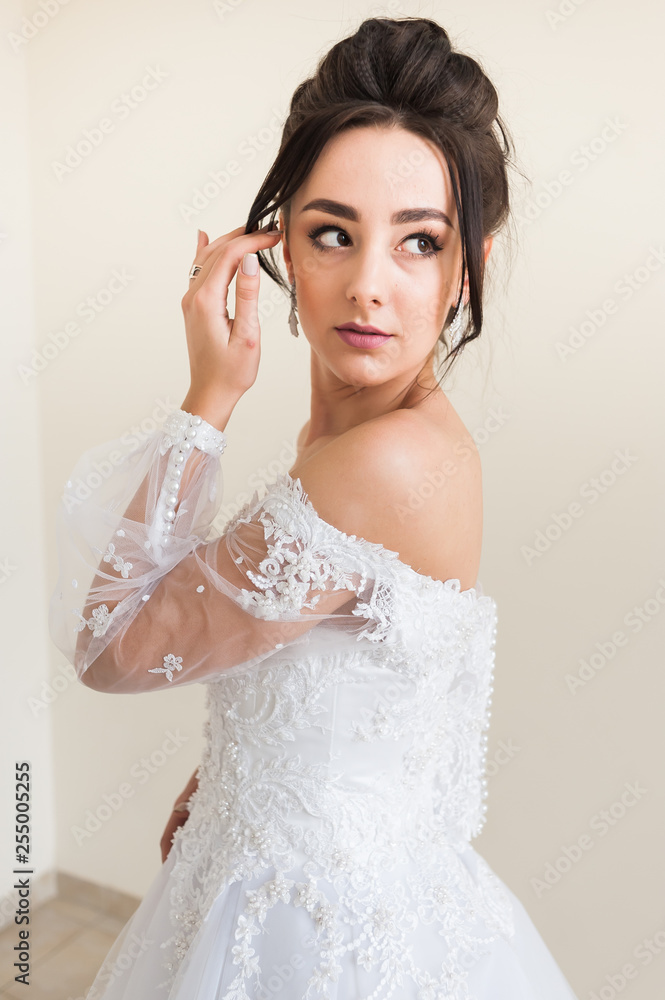 Beautiful bride wearing fashion wedding dress with feathers with luxury delight make-up and hairstyle studio indoor photo shoot Beautiful bride wearing fashion wedding dress with feathers with luxury delight make-up and hairstyle studio indoor photo shoot