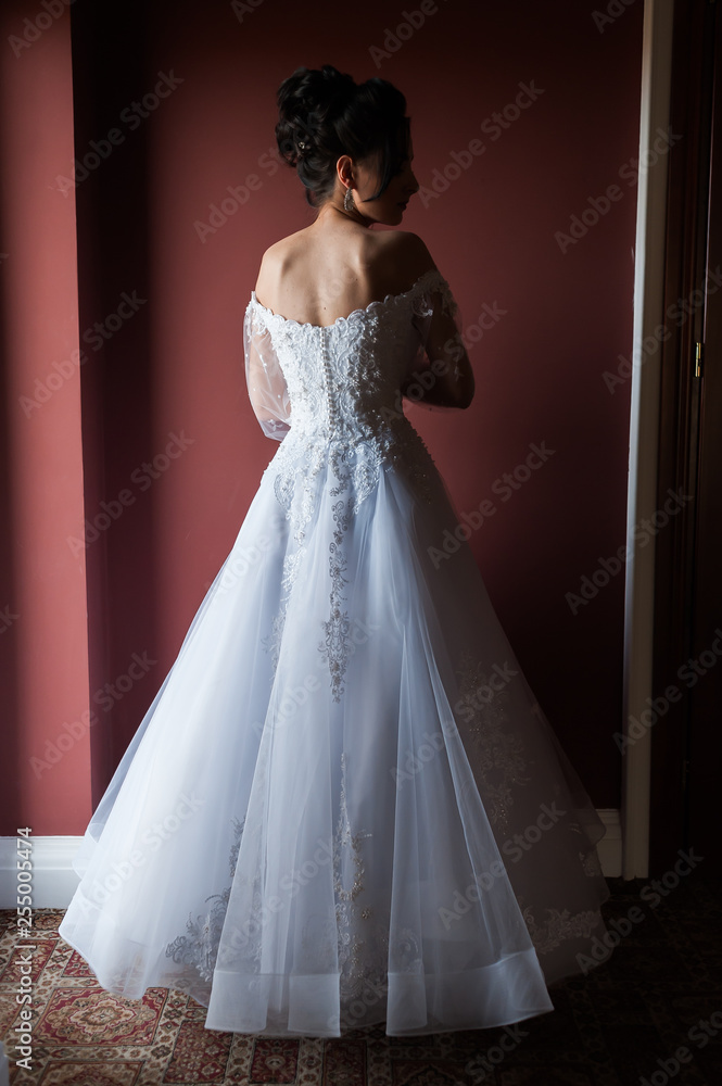 Beautiful bride wearing fashion wedding dress with feathers with luxury delight make-up and hairstyle studio indoor photo shoot Beautiful bride wearing fashion wedding dress with feathers with luxury delight make-up and hairstyle studio indoor photo shoot