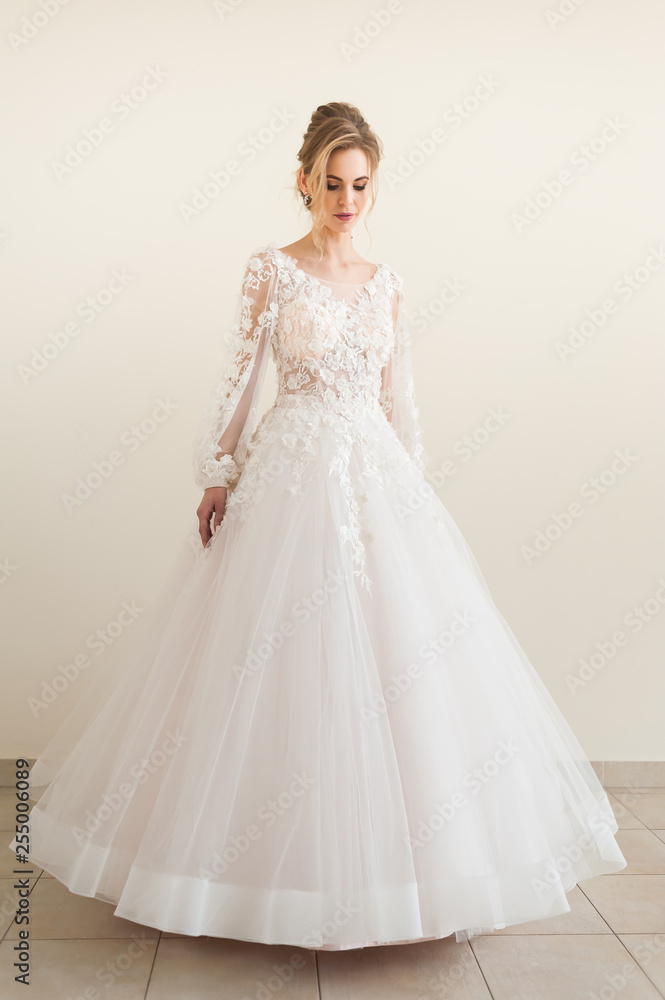 Beautiful bride wearing fashion wedding dress with feathers with luxury delight make-up and hairstyle, studio indoor photo shoot Beautiful bride wearing fashion wedding dress with feathers with luxury delight make-up and hairstyle, studio indoor photo shoot