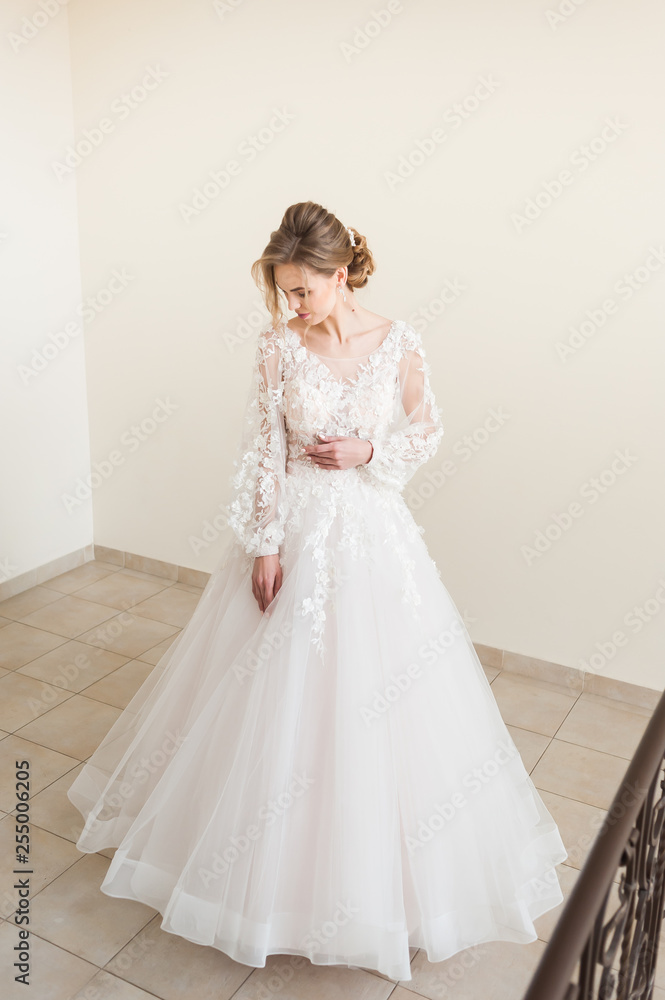 Beautiful bride wearing fashion wedding dress with feathers with luxury delight make-up and hairstyle, studio indoor photo shoot Beautiful bride wearing fashion wedding dress with feathers with luxury delight make-up and hairstyle, studio indoor photo shoot