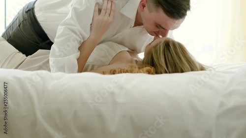 Close-up shot of attractive young couple kissing engaged in foreplay touching each other in the bed at luxury bedroom. 4K photo