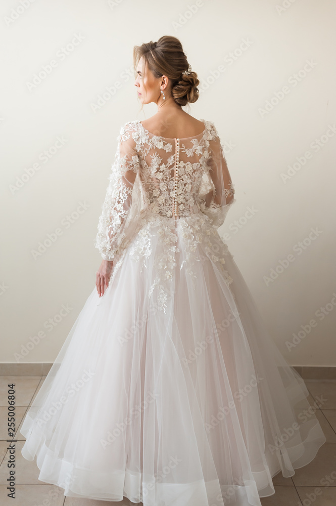 Beautiful bride wearing fashion wedding dress with feathers with luxury delight make-up and hairstyle, studio indoor photo shoot Beautiful bride wearing fashion wedding dress with feathers with luxury delight make-up and hairstyle, studio indoor photo shoot