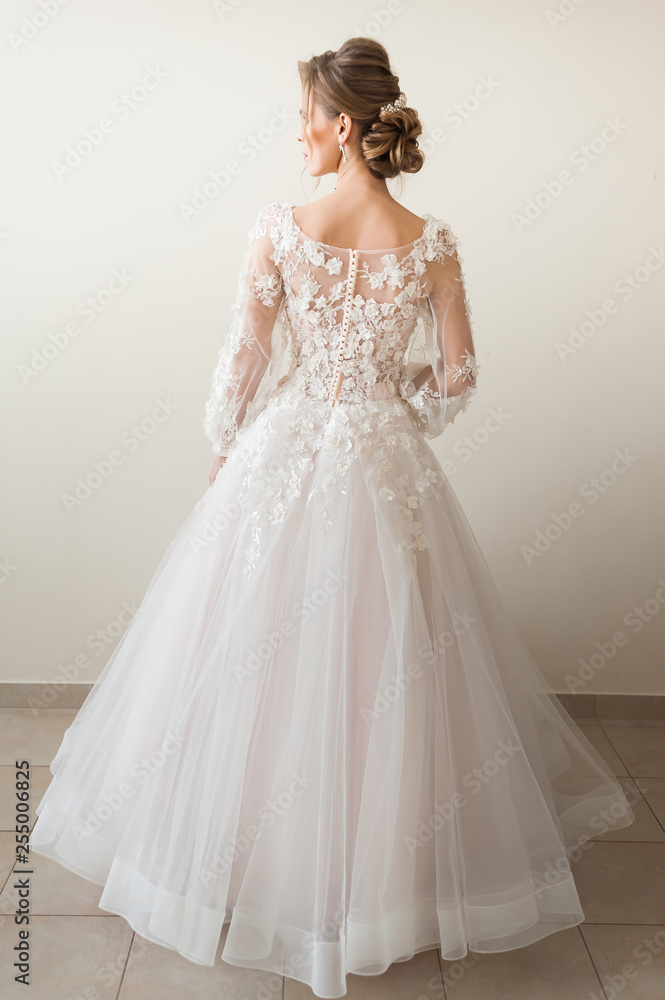 Beautiful bride wearing fashion wedding dress with feathers with luxury delight make-up and hairstyle, studio indoor photo shoot Beautiful bride wearing fashion wedding dress with feathers with luxury delight make-up and hairstyle, studio indoor photo shoot