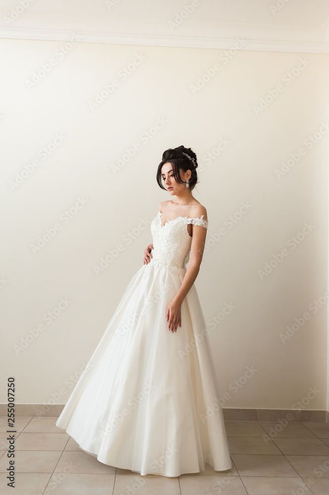 Beauty portrait of bride wearing fashion wedding dress with feathers with luxury delight make-up and hairstyle, studio indoor photo. Beauty portrait of bride wearing fashion wedding dress with feathers with luxury delight make-up and hairstyle, studio indoor photo.