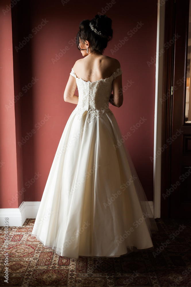 Beauty portrait of bride wearing fashion wedding dress with feathers with luxury delight make-up and hairstyle, studio indoor photo. Beauty portrait of bride wearing fashion wedding dress with feathers with luxury delight make-up and hairstyle, studio indoor photo.