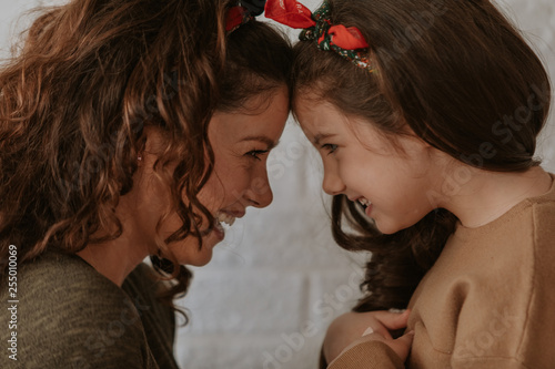 Loving mom and daughter embrace looking in eyes enjoying tender moment together, cute caring mother and child hug touching foreheads, having close strong connection.