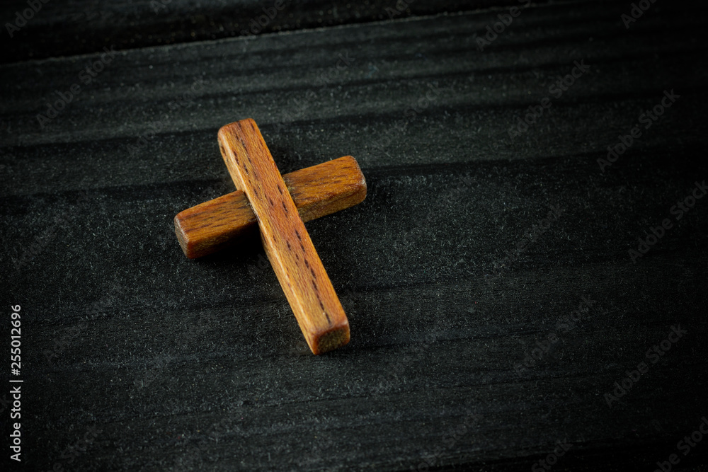 wooden cross on a dark wooden background, space, closeup