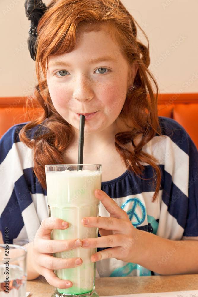 © ML Harris - Portrait of redhead girl drinking milkshake in restaurant © ML Harris - Portrait of redhead girl drinking milkshake in restaurant