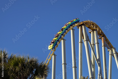 Rollercoaster dropping down at amusement park photo