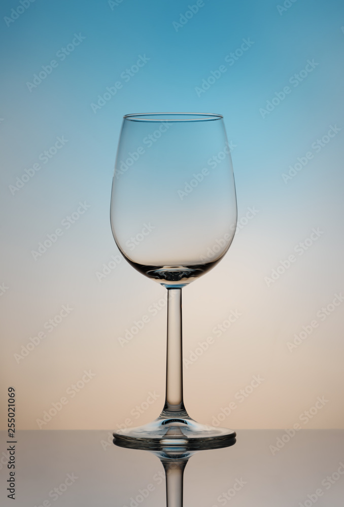 Wine glass on a high and thin stalk on a colored background. Wine glass on a high and thin stalk on a colored background.