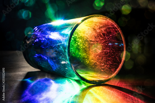 Glass Tumbler on side illumated by rainbow light photo