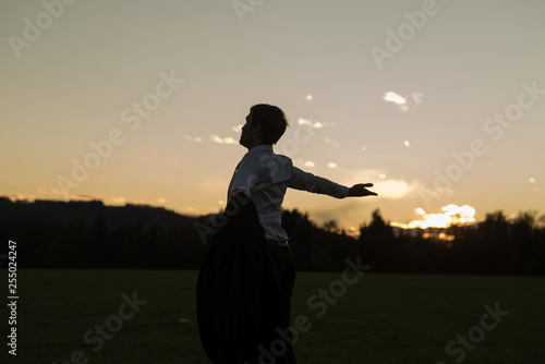 Young businessman enjoying his freedom standing in meadow