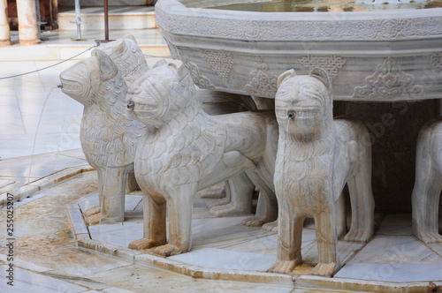 Detail of three statues of the Lion Fountain in the Court of the Lions, beautiful courtyard in the Alhambra of Granada, Spain