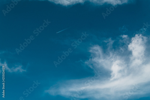ground view of an airplane flying in the big blue sky