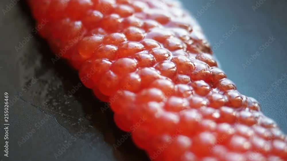 Red Caviar black plate background suggestive focus. Closeup salmon