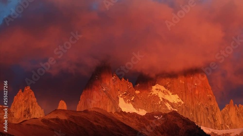 Fitz Roy moundain covered in clouds and highlighted by warm sunrise light photo