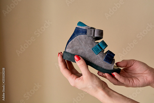 Konstfotografi Female is holding close-up a special children's orthopedic shoe sandals made of genuine leather