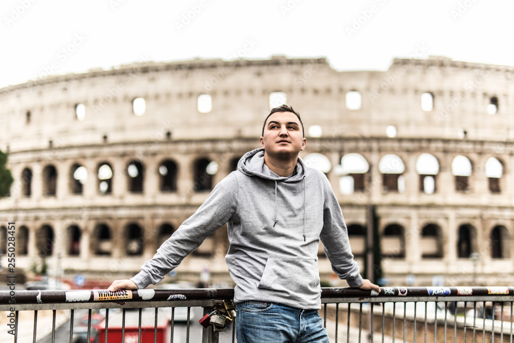 Φωτογραφία Young man travel standing on the street in Rome with Colosseum on background