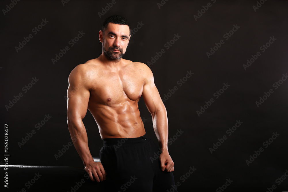 Porter of young muscular man on black background show him body , bodybuilding ,sport 