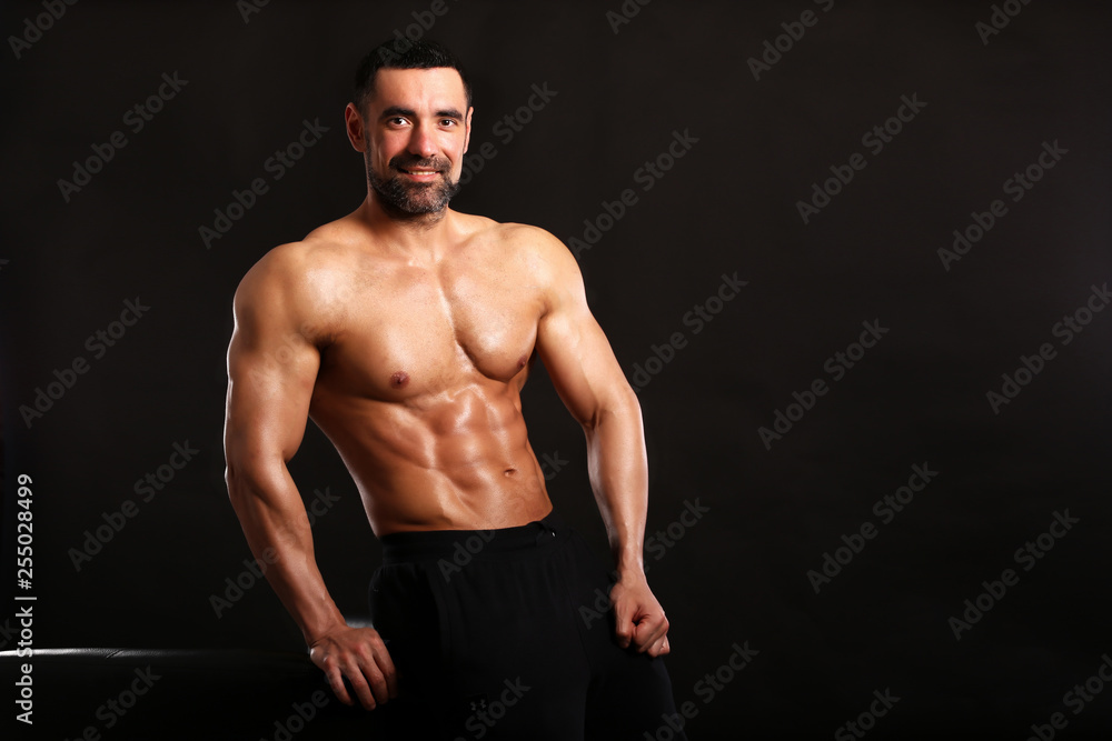 Porter of young muscular man on black background show him body , bodybuilding ,sport 