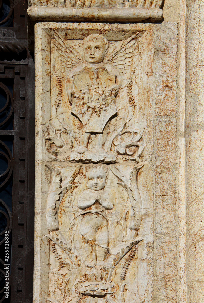 angioletti e simbolo eucaristico; stipite del portale rinascimentale della chiesa di 