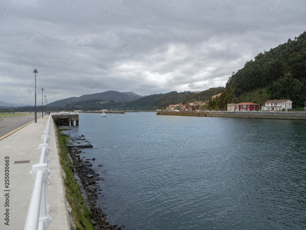 Obraz premium Paisaje del Río Nalón en un día nuboso, Asturias con el pueblo al fondo, verano de 2018