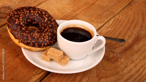 Coffee white cup, croissants on wooden table and roasted coffee beans. Breakfast concept