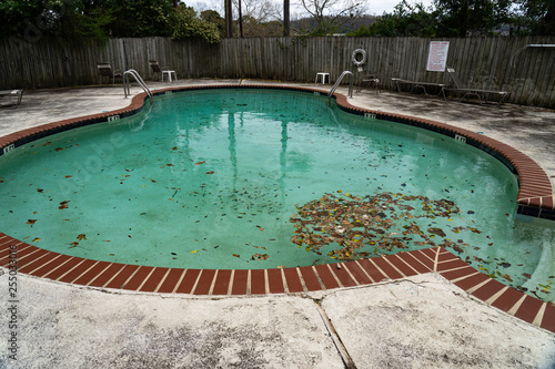 Dirty pool sits unattended covered in leaves