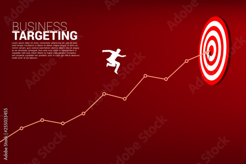 silhouette of businessman jumping on line graph to center of dartboard. Business Concept of targeting and customer.route to success.