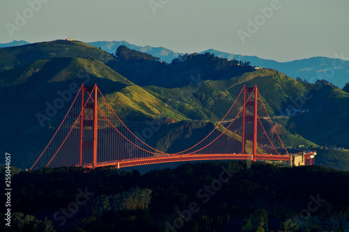 Morning Light hits towers and roadway on the Golden Gate Bridge with Marin headlands in background. View from Sutro Tower over local hills, San Francisco, California   photo