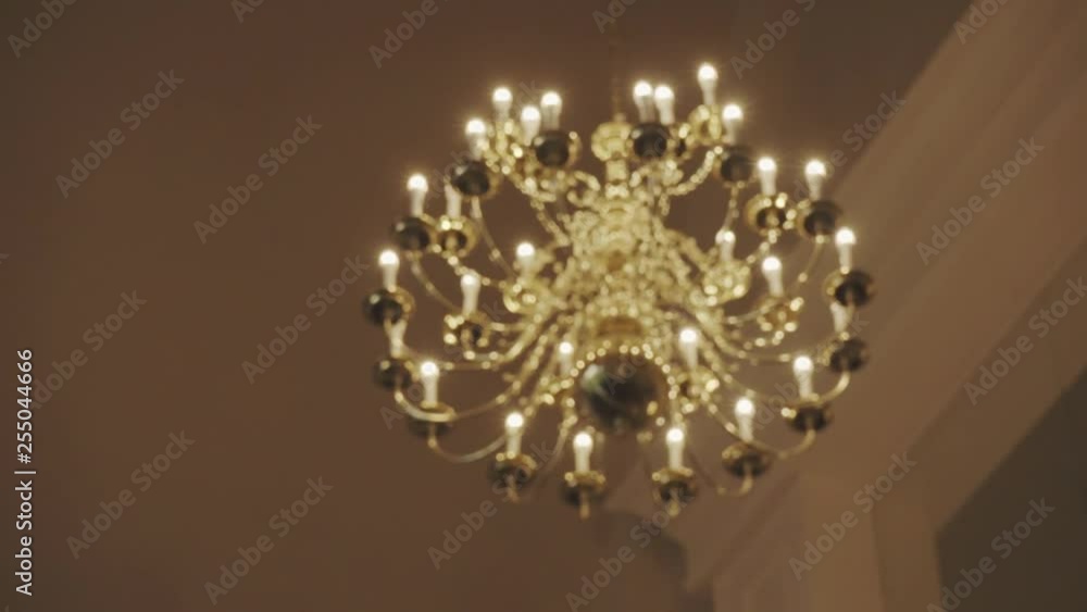 A Large chandelier hanging from the ceiling slowly comes into focus. A Large chandelier hanging from the ceiling slowly comes into focus.