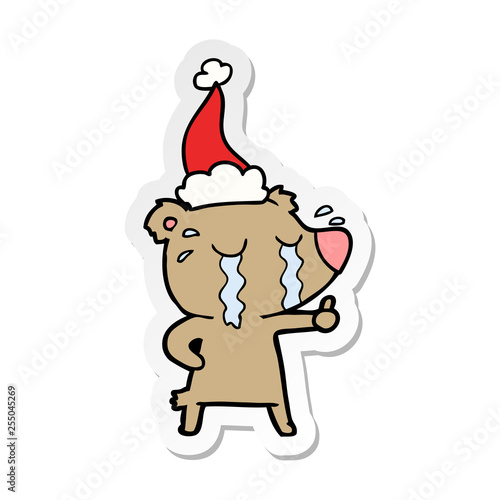 sticker cartoon of a crying bear wearing santa hat