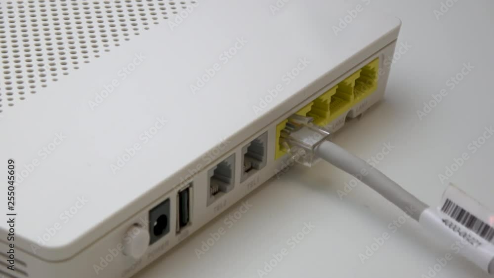 Hand Plugging and Connecting Two Ethernet Cables Wire Cords To White WiFi Router, Side Shot Hand Plugging and Connecting Two Ethernet Cables Wire Cords To White WiFi Router, Side Shot