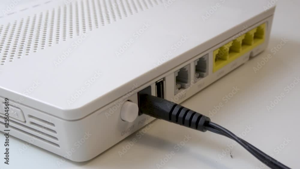 Hand Plugging, Connecting, Unplugging and Disconnecting Power Cable Wire Cord From White WiFi Router, Side Shot, Powering Router On and Off Hand Plugging, Connecting, Unplugging and Disconnecting Power Cable Wire Cord From White WiFi Router, Side Shot, Powering Router On and Off