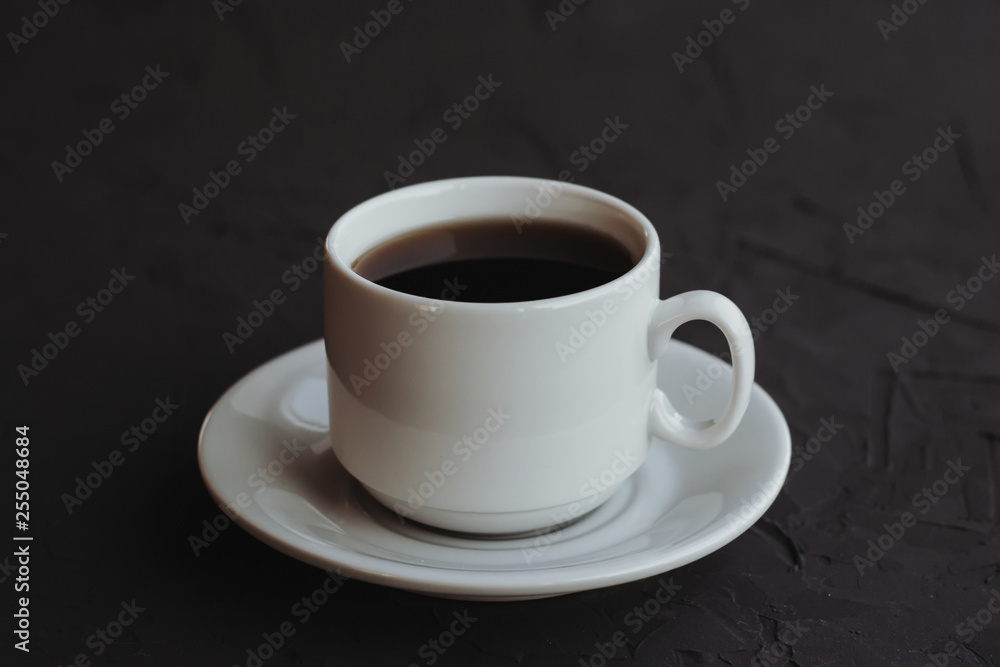 White cup of coffee on a dark background White cup of coffee on a dark background