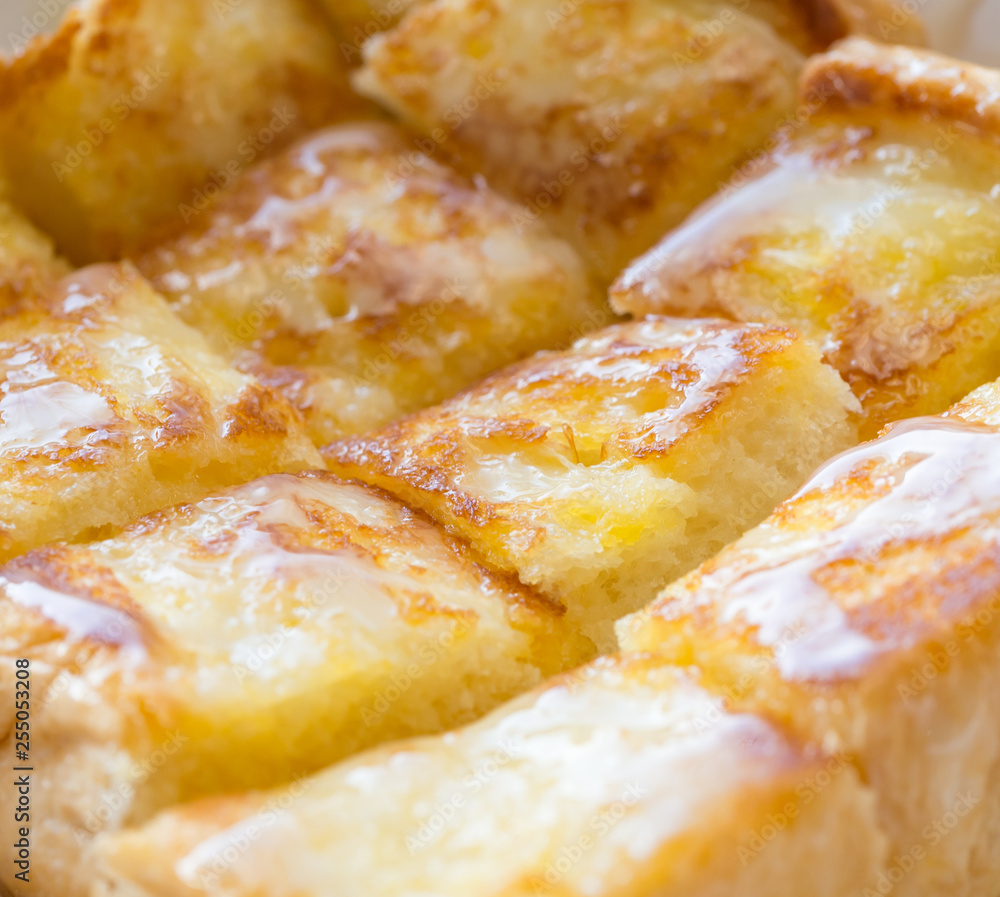 Closeup picture of one bread with butter and sweet milk in paper plate.