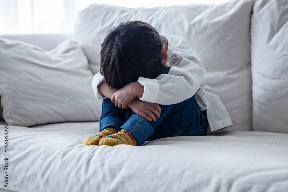 ソファの上でうずくまる男の子 Stock Photo | Adobe Stock