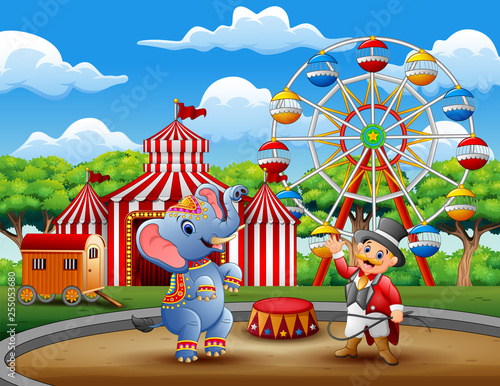 Circus ringmaster performs a trick along with elephant in arena