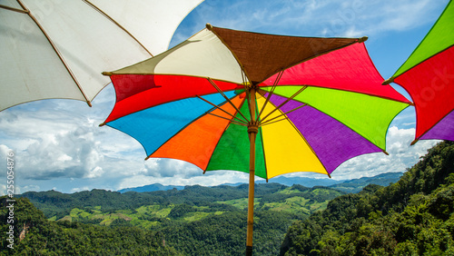 Rainbow umbrella on the blue sky.
