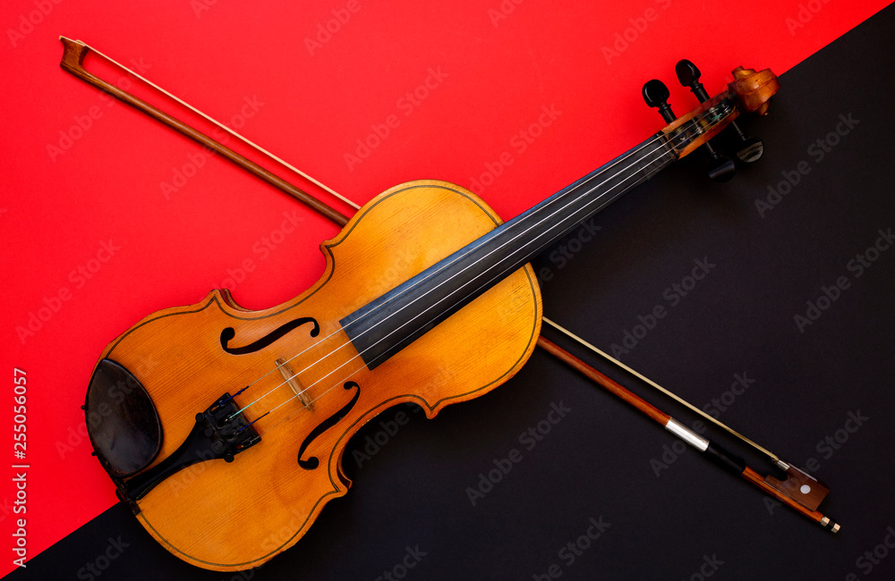 Fototapeta premium Violin and bow on a red and black background