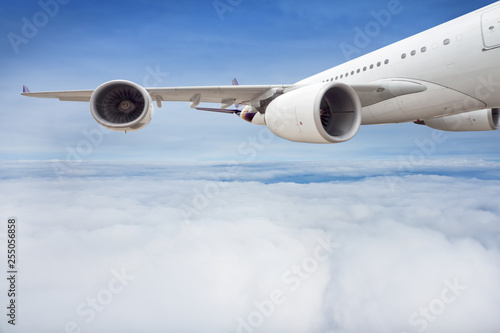 Wing and engine of passenger airplane is flying in the sky.