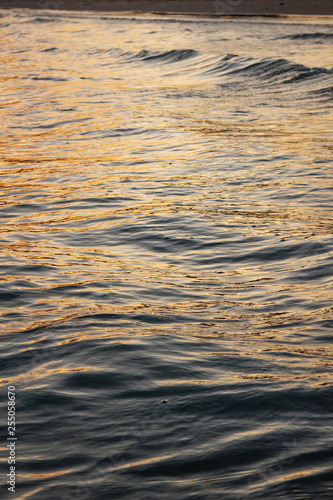 Sea wave surface that reflected with blue, yellow sky color in the evening in Koh Mak Island at Trat, Thailand.