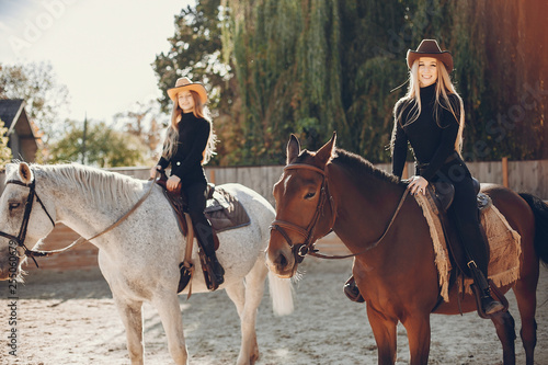 Girls with a horse. Women in a ranch. Blonde in a black sweater