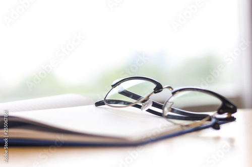 Black glasses on notebook on table.Close-up glasses.